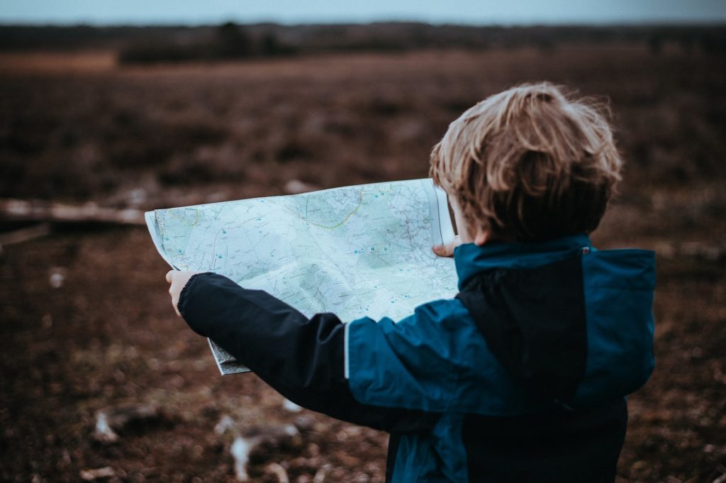 foto de criança com mapa como viajar com crianças