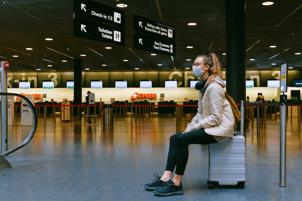 imagem de mulher esperando em aeroporto para viajar com segurança